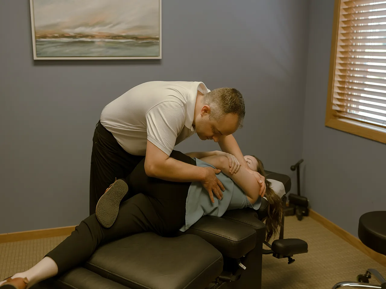 Dr. David performing a side-posture lower back adjustment